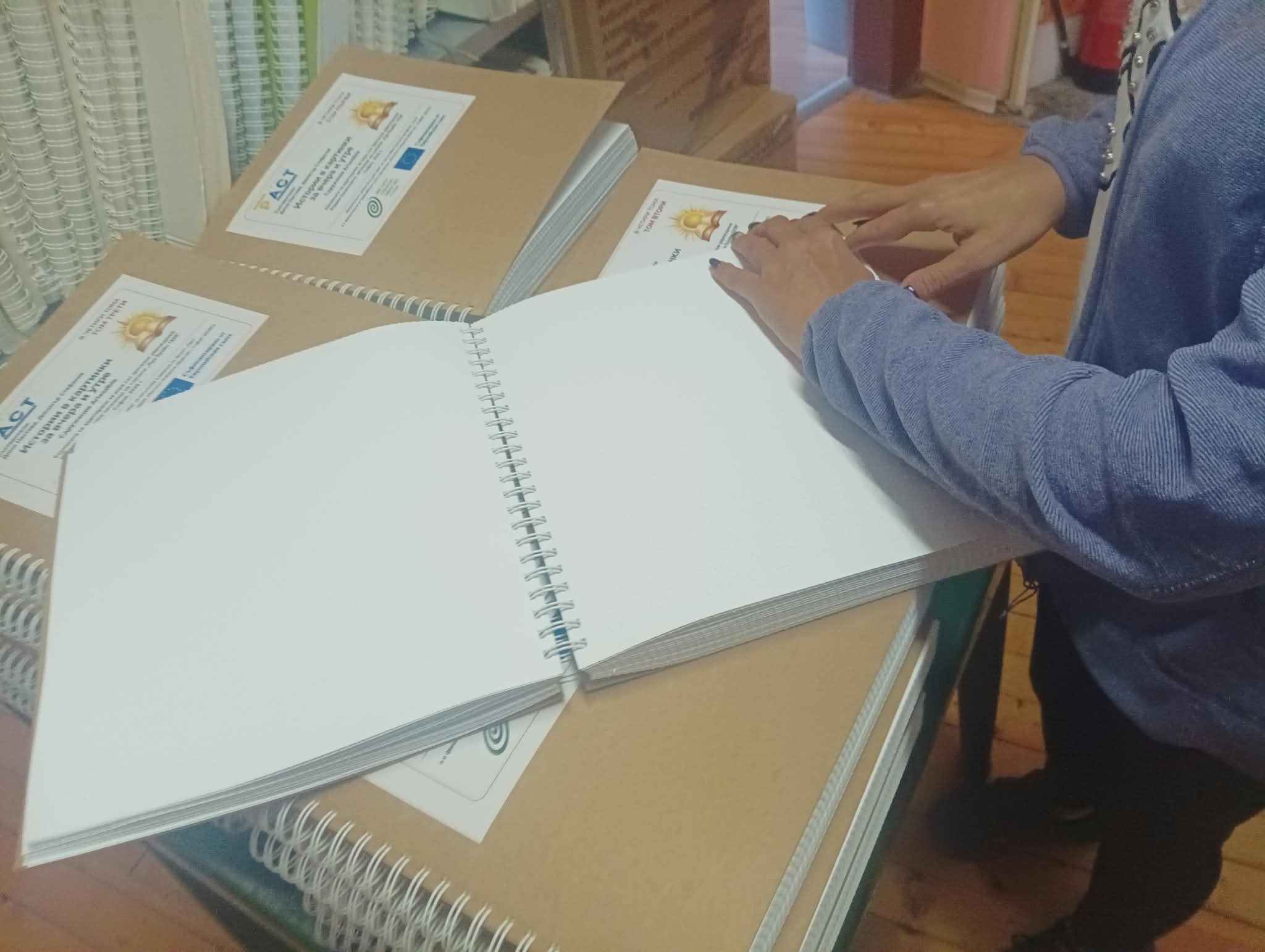 „Изкуство в действие“: 15 нови комикса за незрящи 139 Ръце върху отворени страници на брайлов комикс
